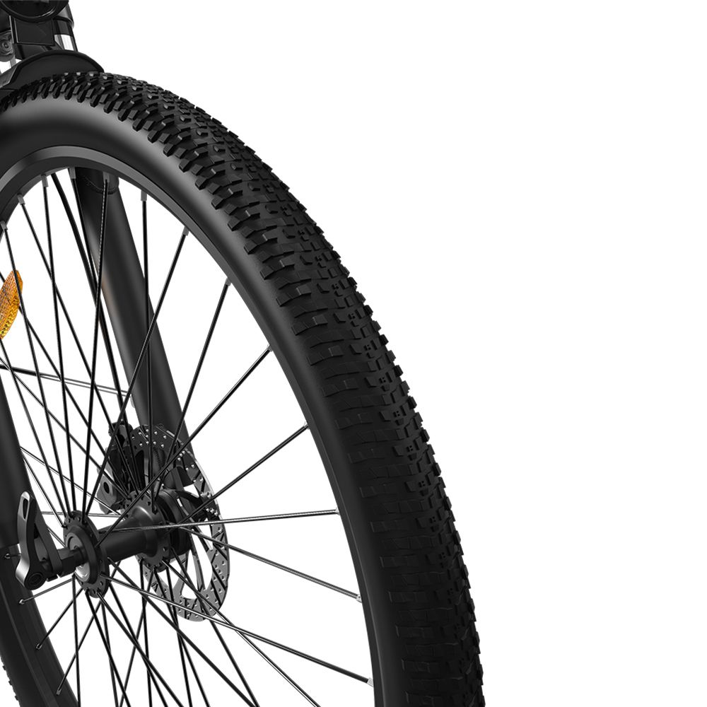 Nahaufnahme des Vorderrads eines schwarzen Elektrofahrrads. Schwarzer Reifen mit Profil. Speichen und Bremsscheibe sichtbar.