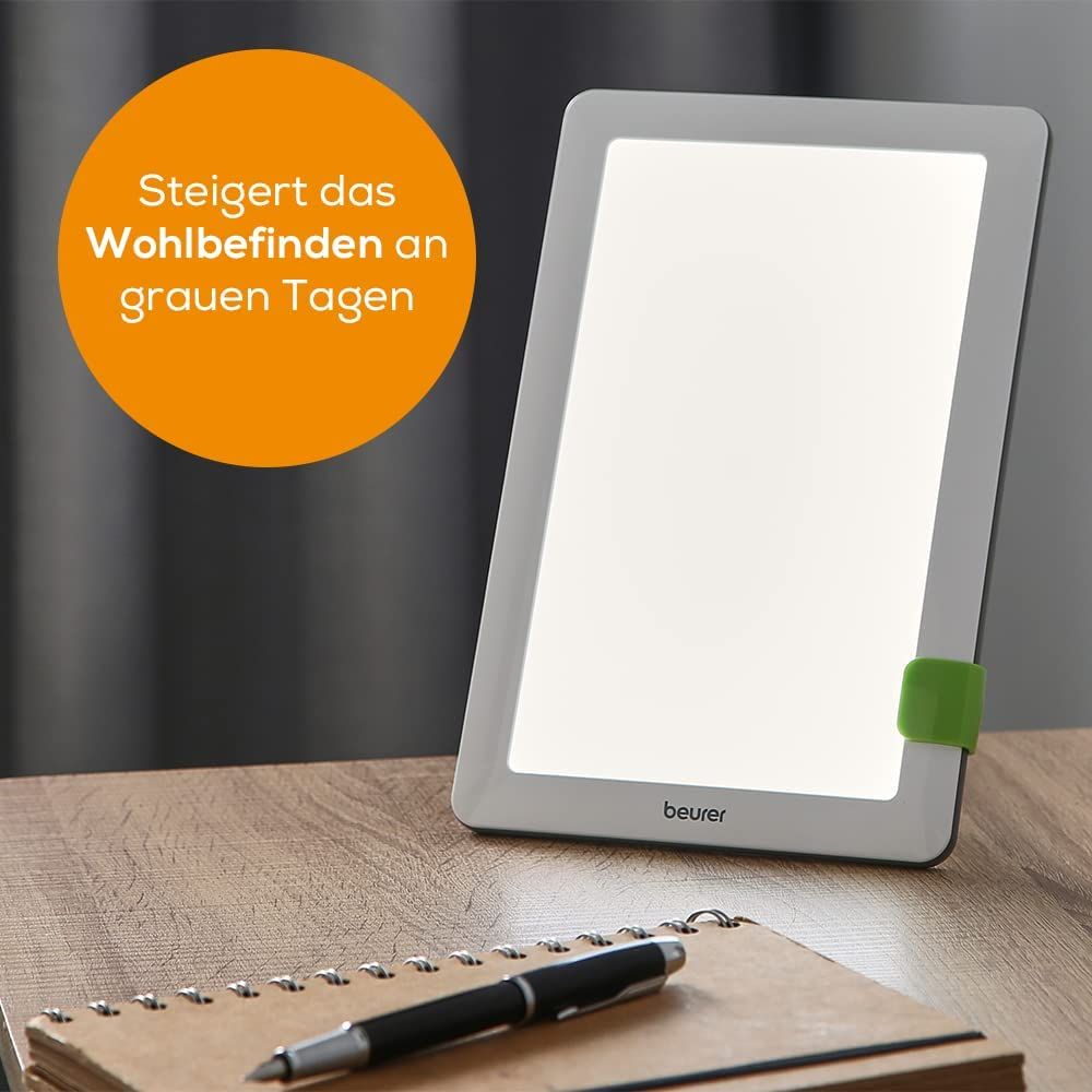 Tageslichtlampe auf Tisch. Text: Steigert das Wohlbefinden an grauen Tagen. Marke: beurer.