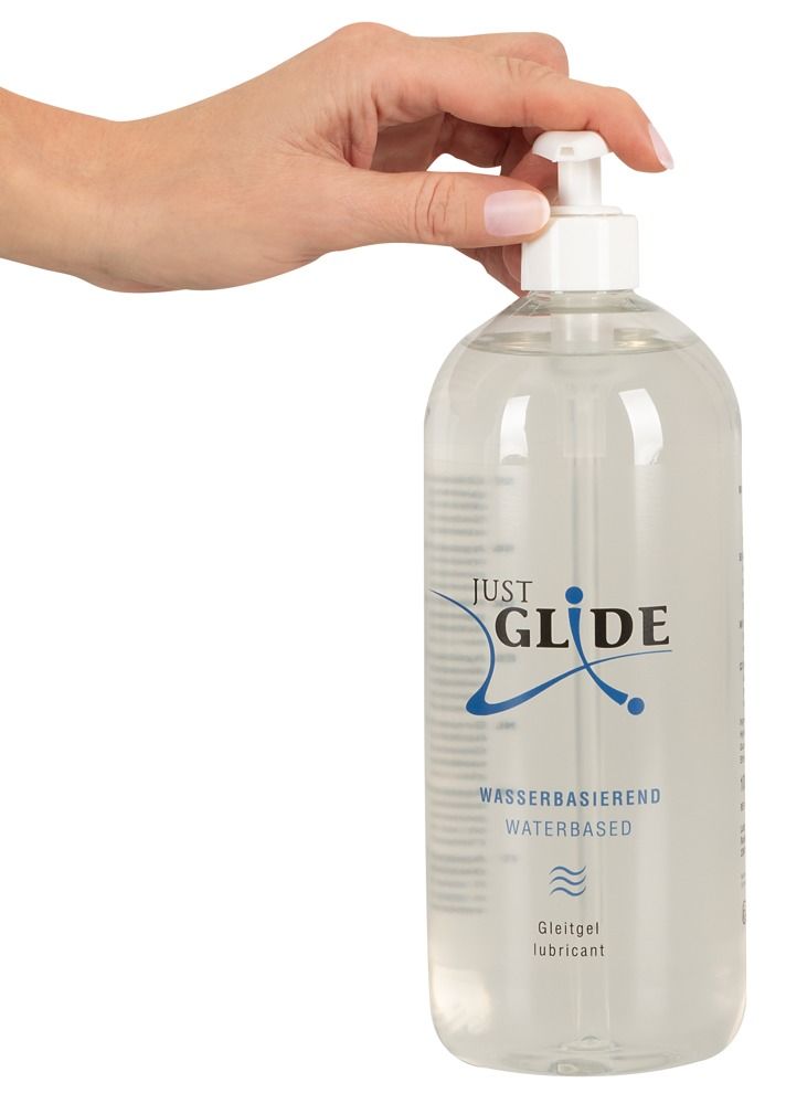 Hand bedient Dosierpumpe einer transparenten Flasche. Aufschrift: JUST GLIDE, Wasserbasiert, Medizinische Gleitgel.