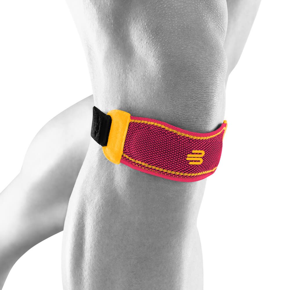 Kniestrap am Knie. Rot mit gelbem Logo. Klettverschluss. Mesh-Material.