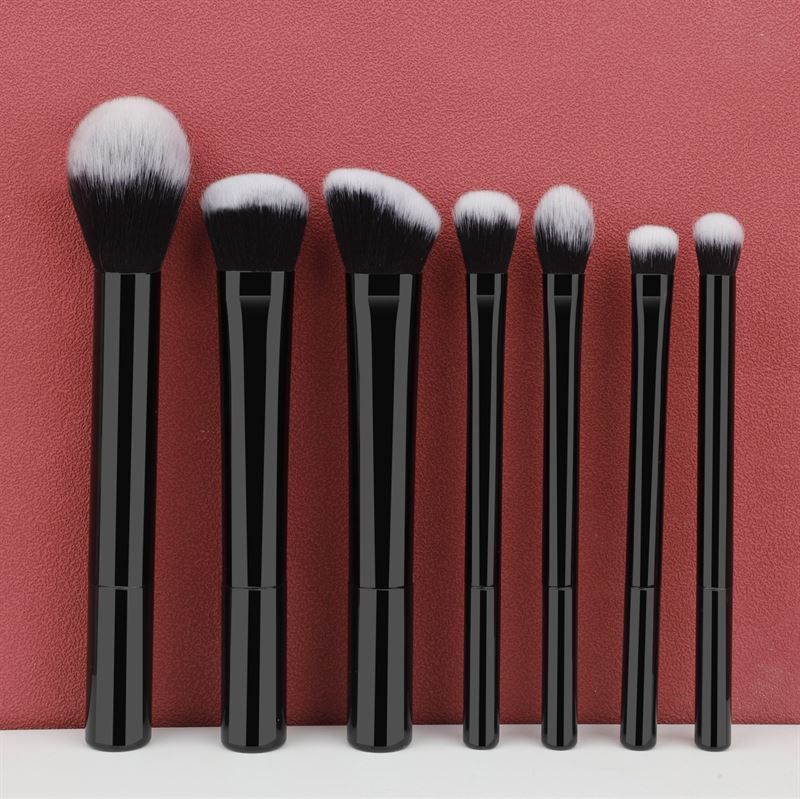 Set mit sieben schwarzen Make-up-Pinseln mit weißen Borsten. Unterschiedliche Formen und Größen.