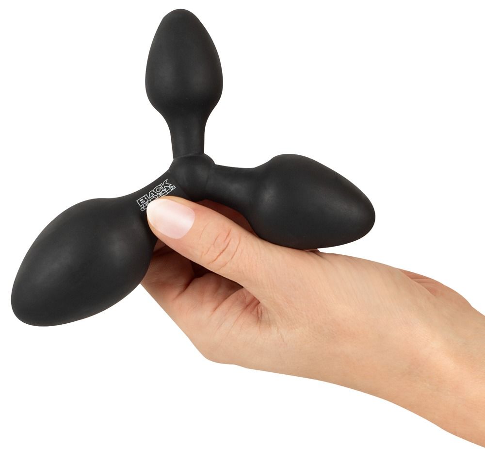 Schwarzer, dreiteiliger Analplug. Drei konisch geformte Enden, verbunden durch einen zentralen Knoten. In Hand gehalten.