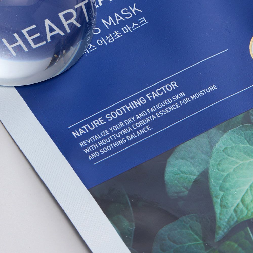 Blaue Verpackung mit Text: "NATURE SOOTHING FACTOR" und Blättern. Eine transparente Kugel liegt daneben.
