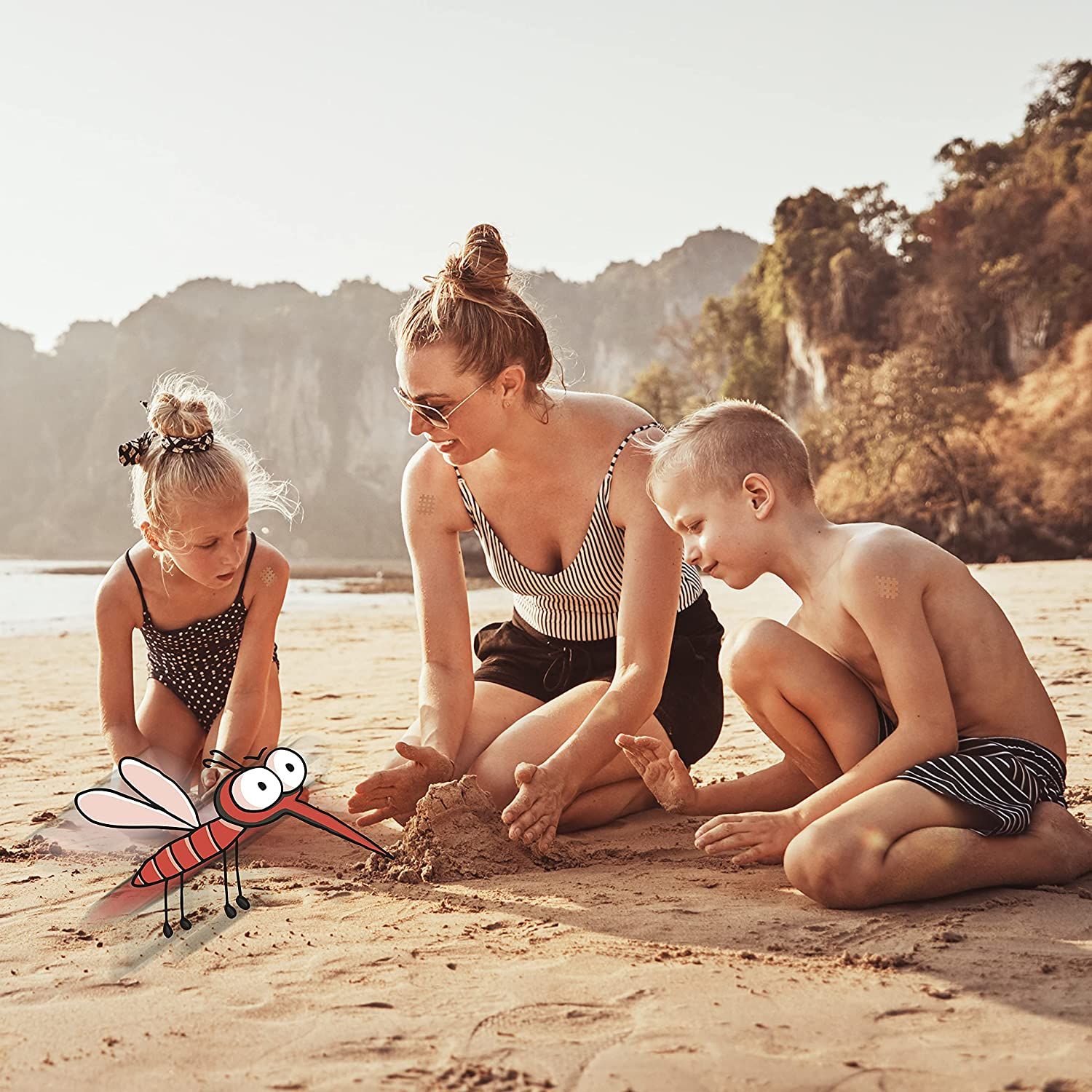 Familie am Strand. Kinder spielen im Sand, eine Frau sitzt daneben. Cartoon-Mücke im Vordergrund.