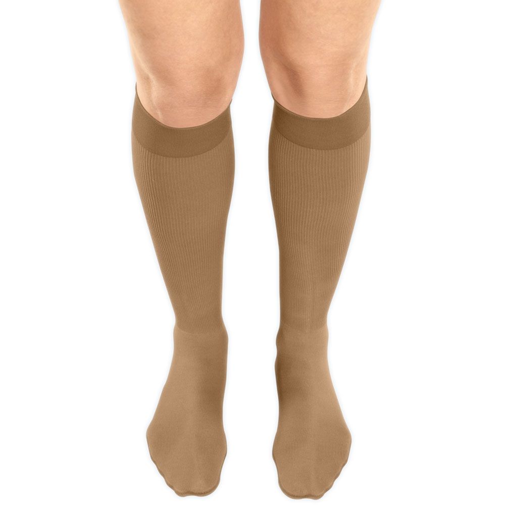 Beige Kompressionsstrümpfe am Bein. Trikotabschlussrand, Kniestrümpfe.
