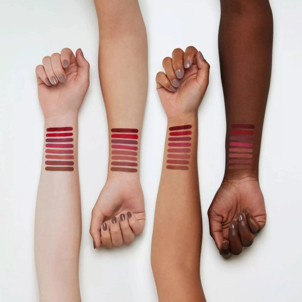 Arme mit Lippenstiftfarben auf der Haut. Verschiedene Hauttöne. Mehrere Farbtöne in Streifen aufgetragen.