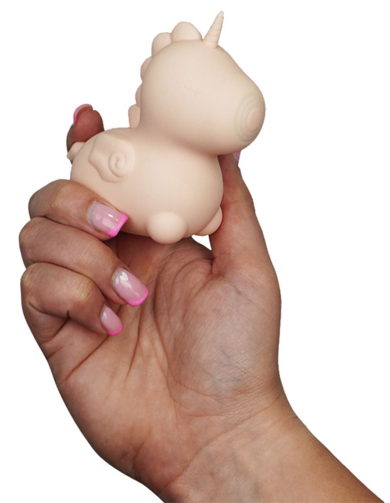 Hand hält rosa Einhorn-Vibrator. Rosa, mit geschlossenen Augen. Flügel und Horn.