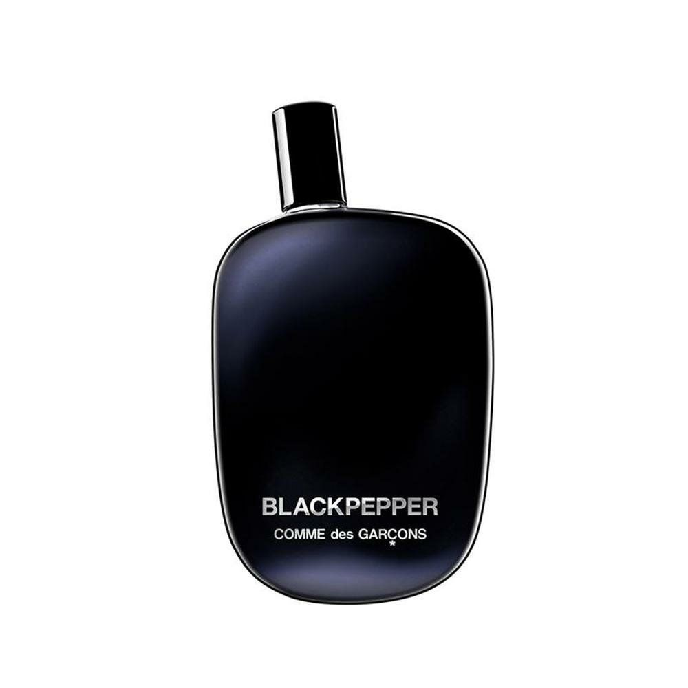 Schwarze Flasche mit schwarzem Verschluss. Aufschrift: Blackpepper, Comme des Garçons. Eckige Form mit abgerundeten Kanten.
