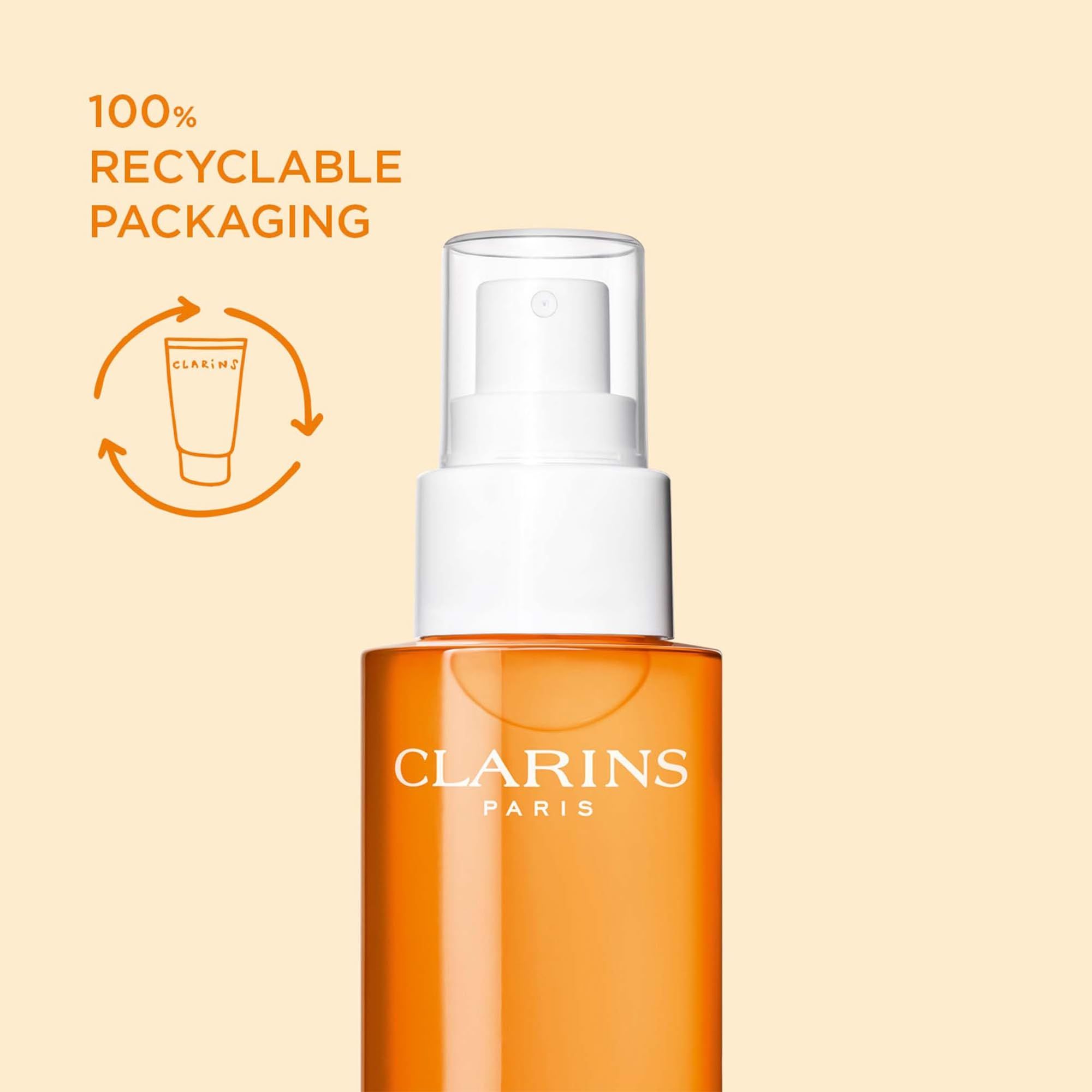 Orangefarbene Sprühflasche mit weißem Sprühkopf. Text: 100% RECYCLABLE PACKAGING. Clarins Logo und Recycling-Symbol.