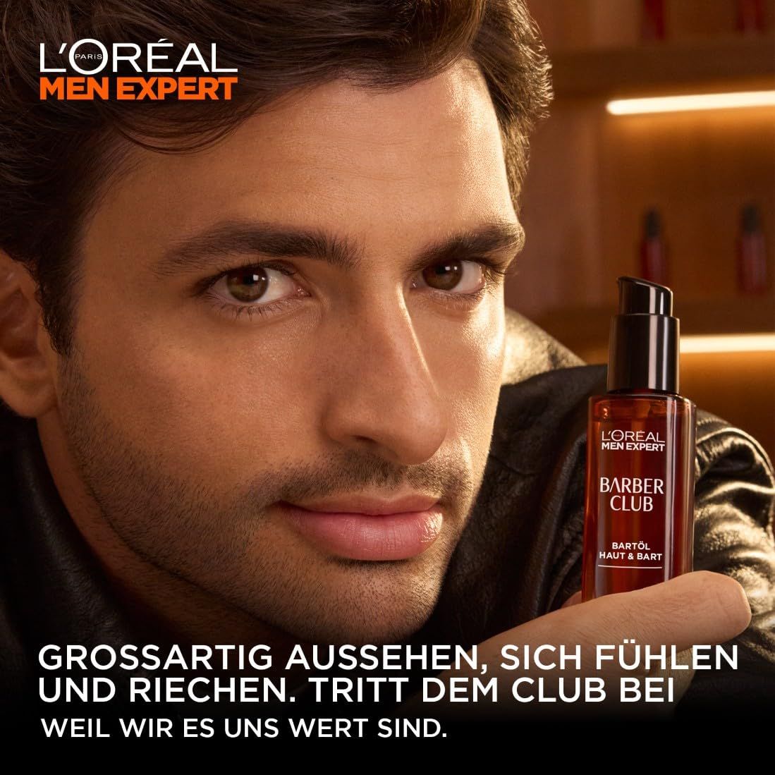 Mann hält L'Oréal Men Expert Barber Club Bartöl. Braune Flasche mit schwarzem Pumpverschluss. Markenlogo.