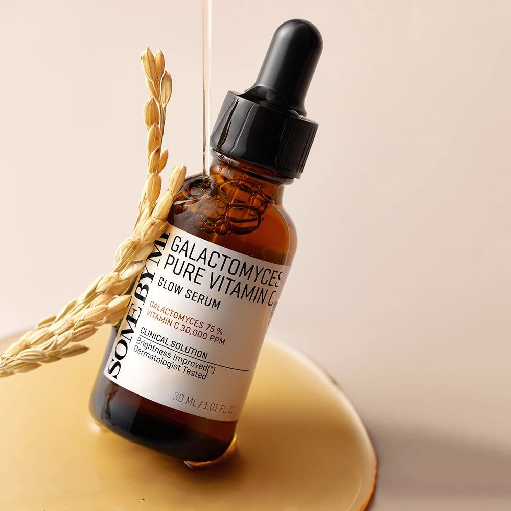 Braune Glasflasche mit schwarzem Tropfer. Etikett mit Produktnamen und Inhaltsstoffen. Tropfen Serum fließen aus der Flasche.