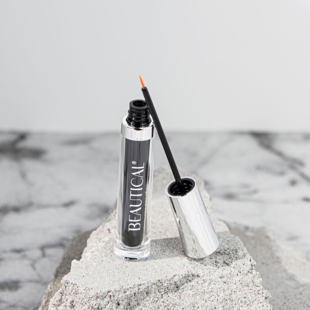 BEAUTICAL Eyelash Enhancing Serum. Schwarze Flasche, silberne Kappe, Applikator.