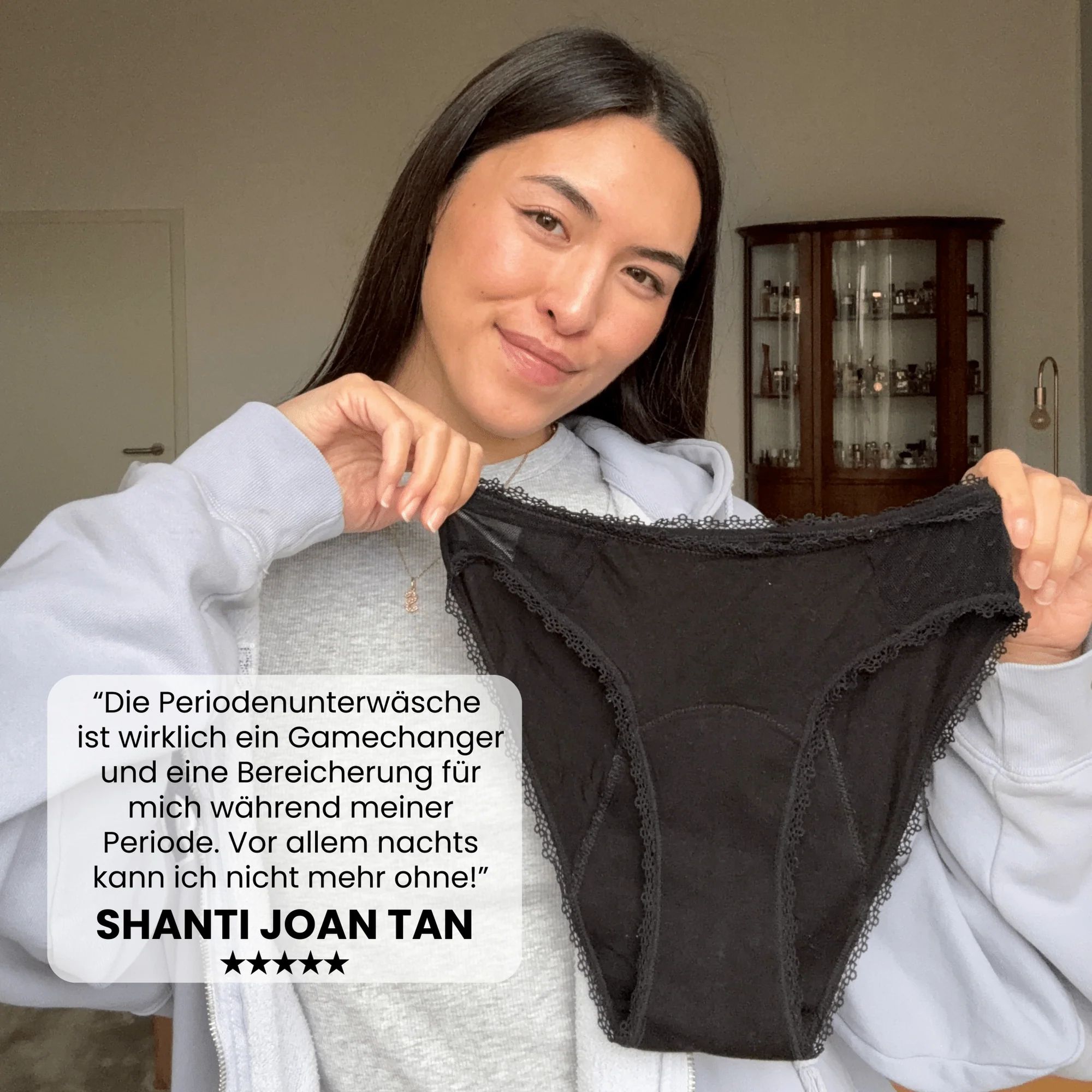 Eine Person hält einen schwarzen Slip mit Spitze. Text: Die Periodenunterwäsche ist ein Gamechanger.