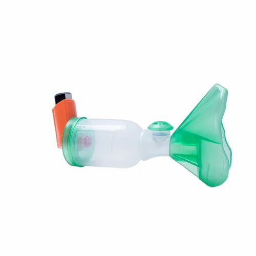 Medikamentenspacer mit Inhalator und Maske. Transparenter Behälter mit grüner Maske und orangefarbenem Inhalator.