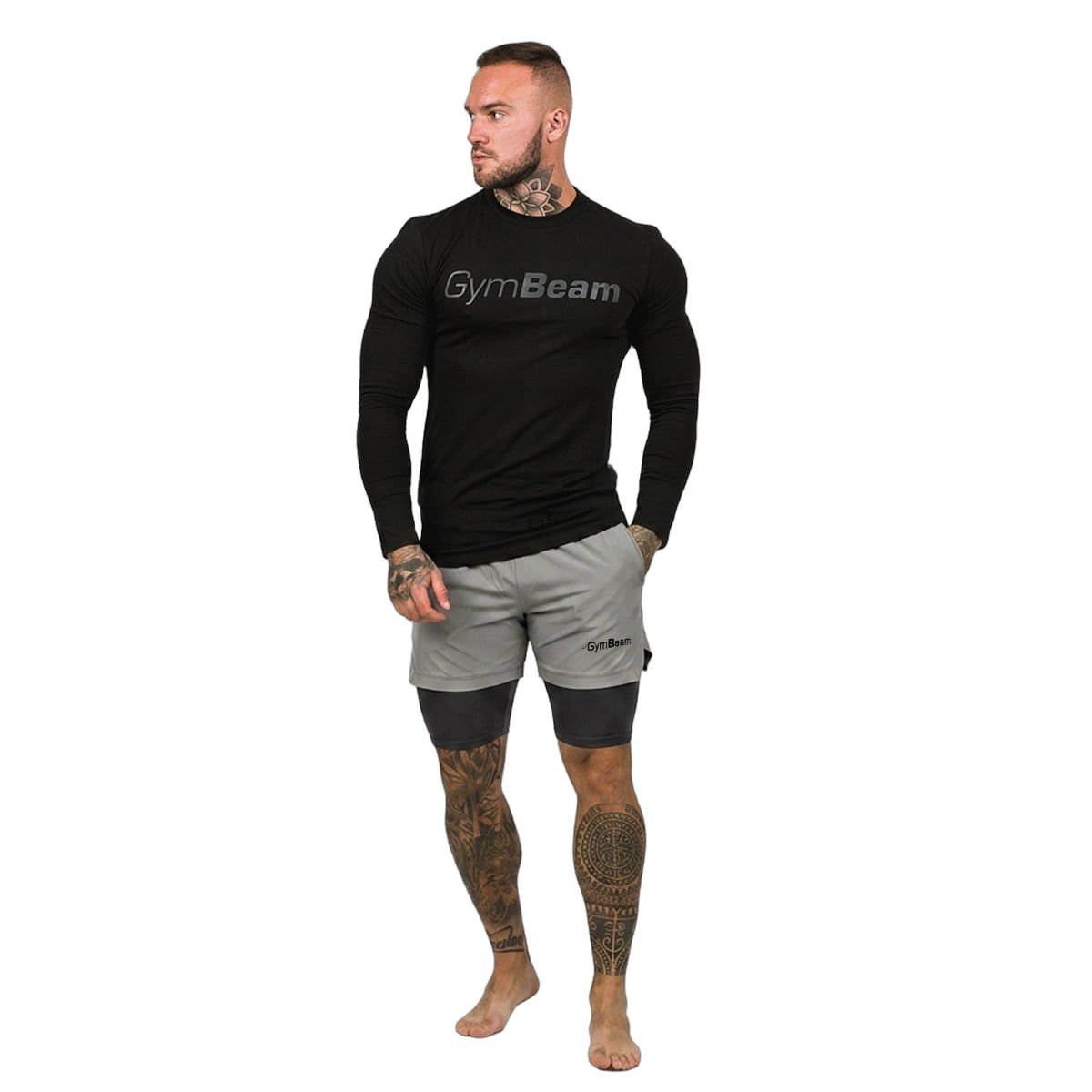 Mann in grauen 2-in-1-Shorts mit schwarzem Langarmshirt, beide mit GymBeam-Logo.