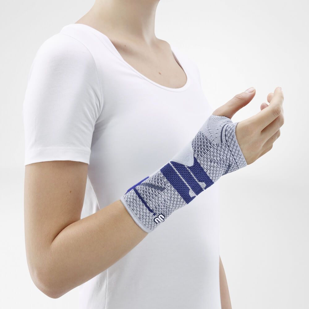 Frau mit weißem T-Shirt trägt eine Handgelenkbandage. Grau-blaues Design, Logo.
