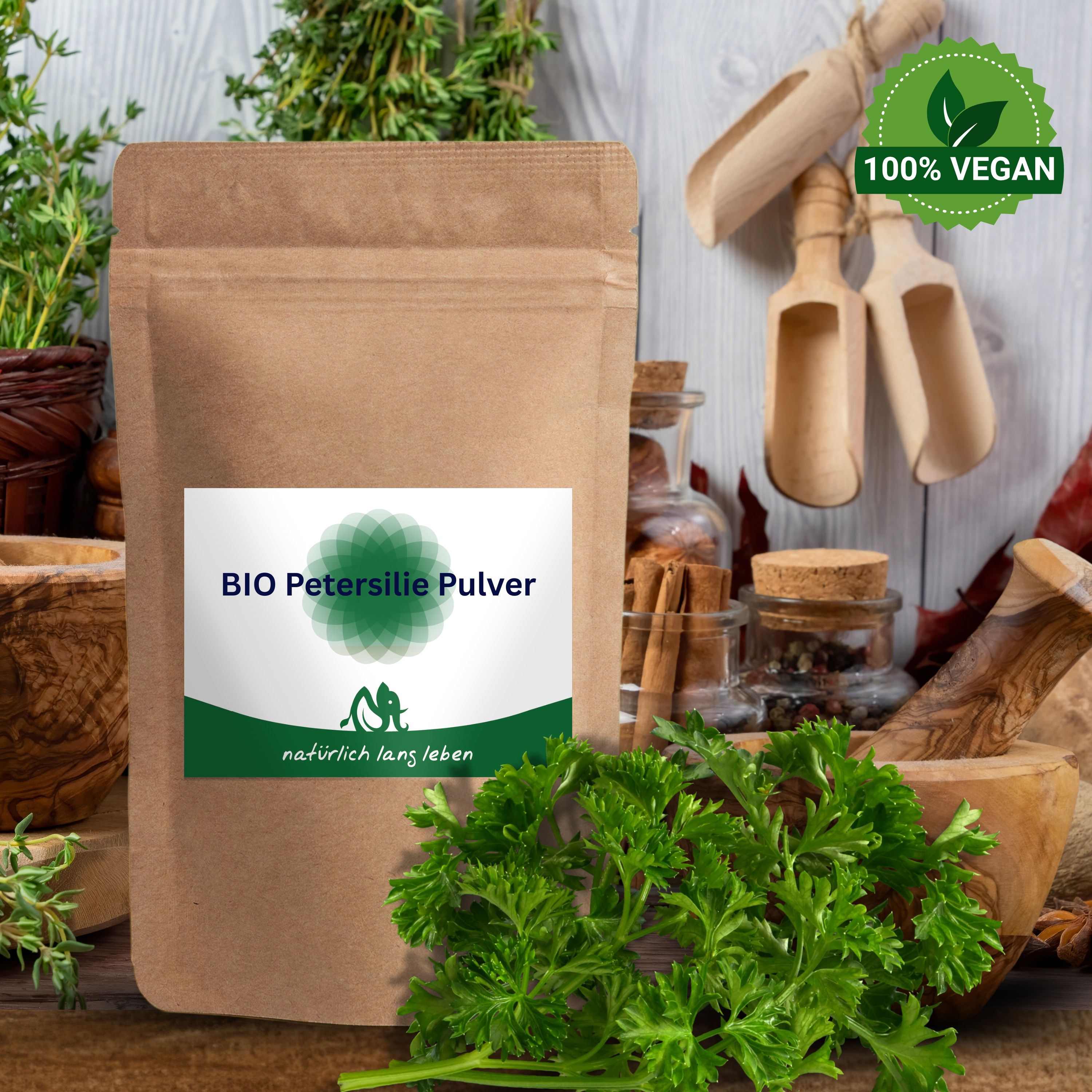 Braune Tüte mit Etikett „BIO Petersilie Pulver“. Grünpflanze und Holzutensilien auf Holzuntergrund. Vegan-Siegel.