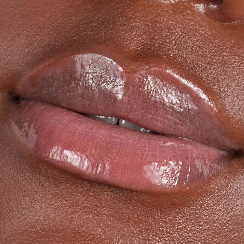 Nahaufnahme von Lippen mit aufgetragenem Lipgloss. Glänzendes Finish.