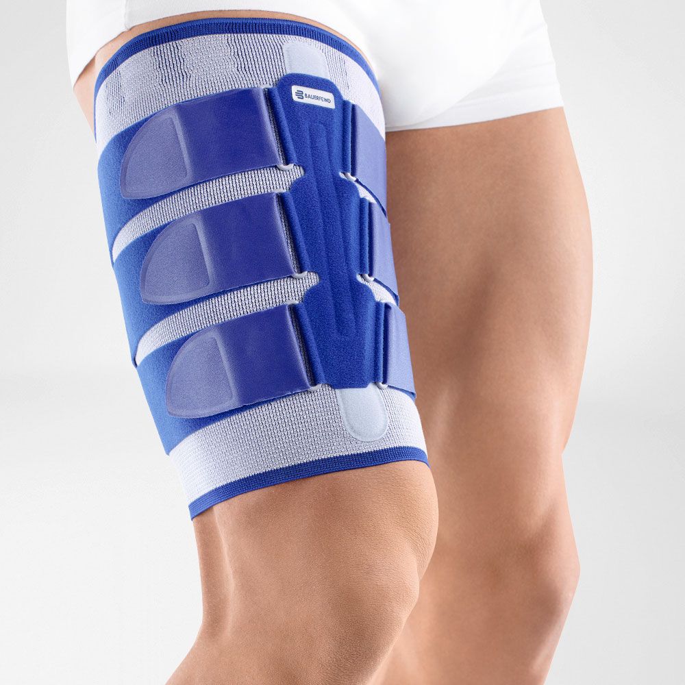 MyoTrain Oberschenkel-Aktivbandage am Bein. Blau-weißes Design mit Klettverschlüssen.