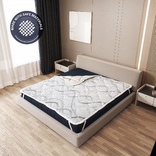 Matratzenschoner auf einem Bett, mit Siegel 'Made with safe materials'.