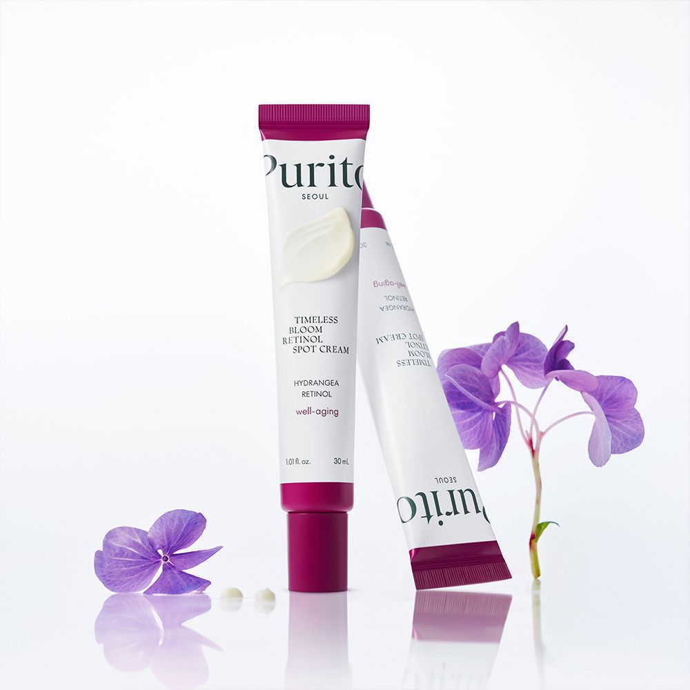 Zwei PURITO Timeless Bloom Retinol Spot Cream Tuben mit Blüten.