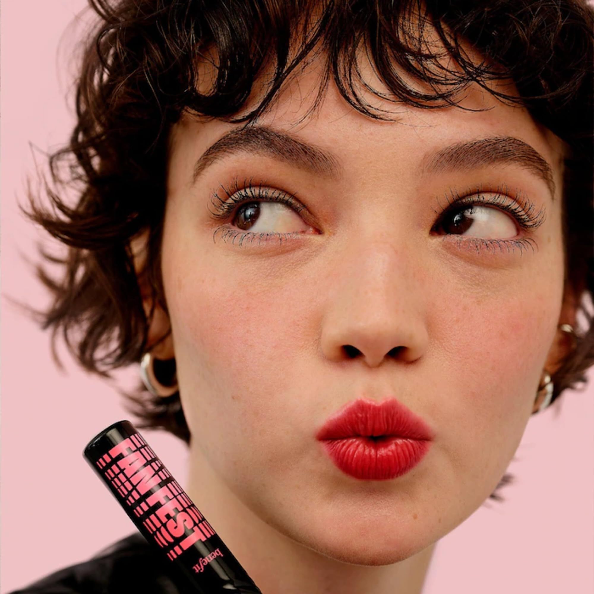 Porträt einer Frau mit Mascara. Die Mascara ist sichtbar, das Produkt ist nicht im Fokus.