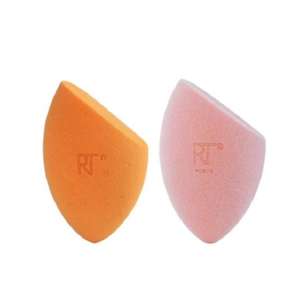 Zwei Make-up-Schwämme in einer Verpackung. Ein orangefarbener und ein rosafarbener Schwamm. Text: REAL TECHNIQUES, iconic blend + set sponge duo.