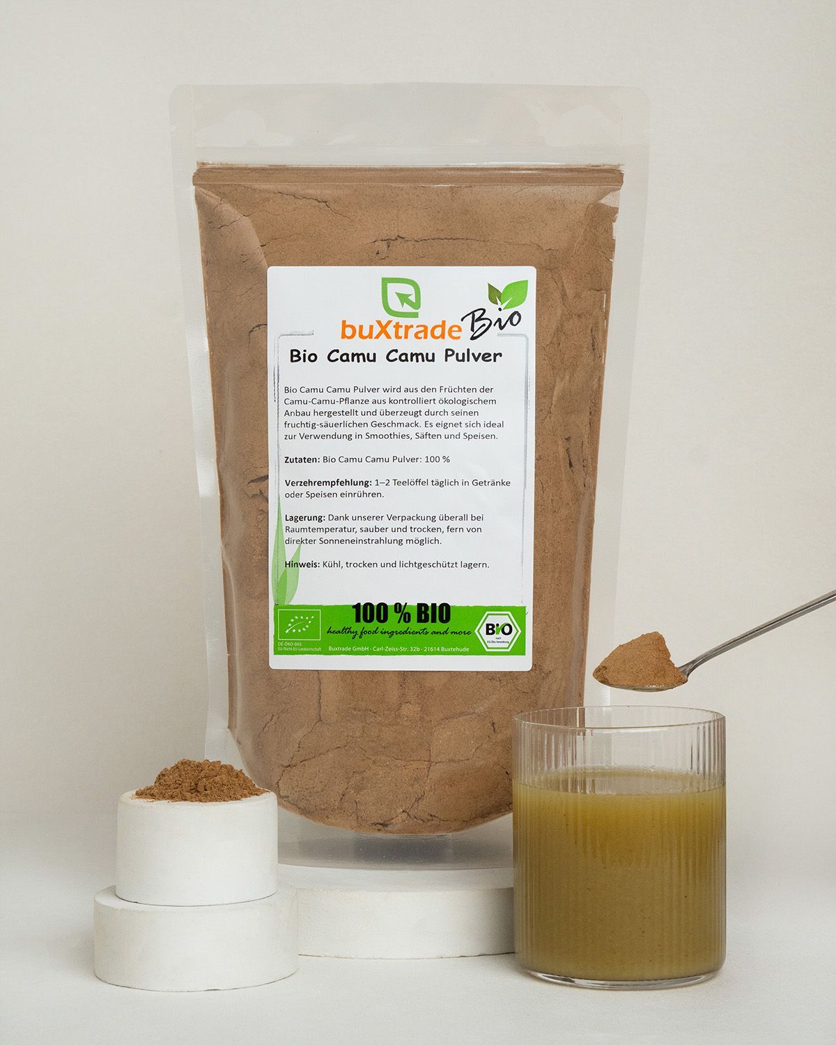 Bio Camu Camu Pulver in Verpackung, Behälter, Glas und Löffel.