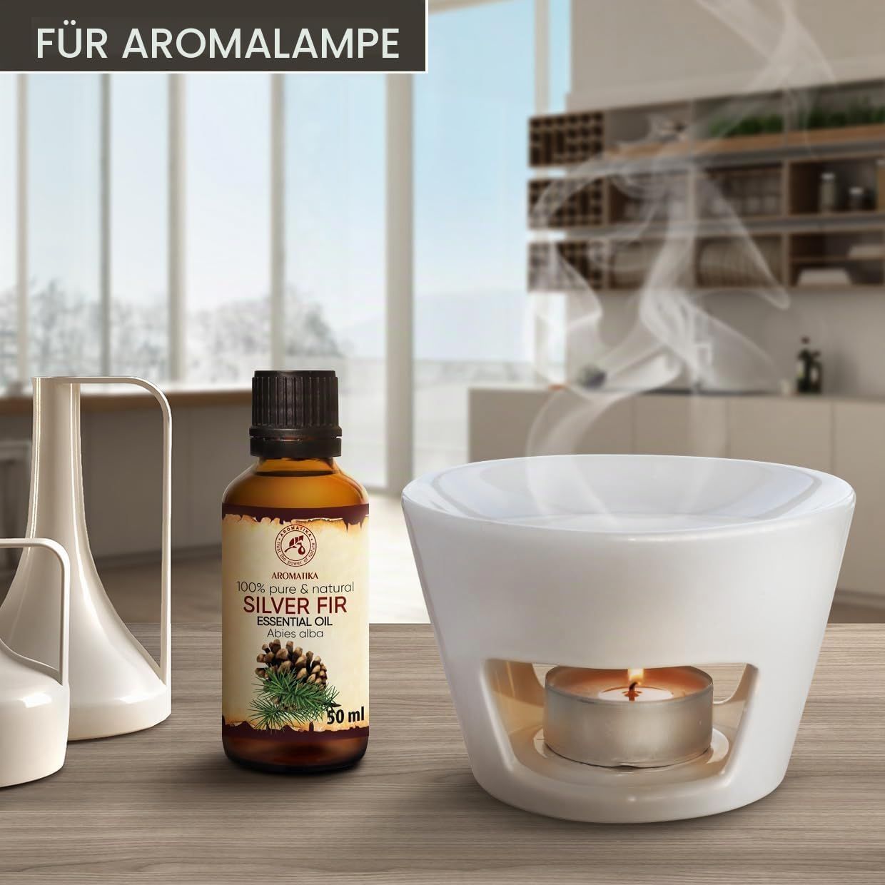 Flasche Silber-Tanne-Ätherisches Öl neben Aromalampe mit brennender Kerze.