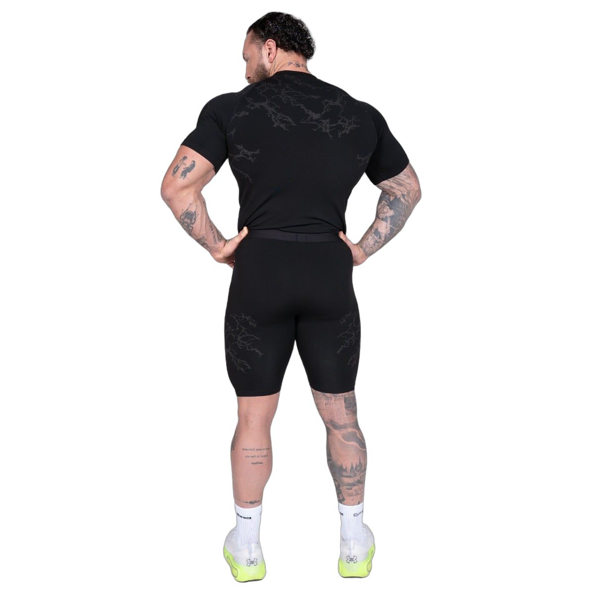 Mann in schwarzen Shorts und T-Shirt, Rückansicht. Nahtloses Design, elastischer Bund.