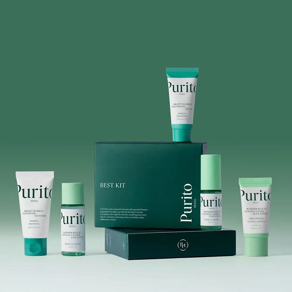 Verschiedene Hautpflegeprodukte in Reisegröße. Grün-weiße Tuben und Flaschen, angeordnet vor einer grünen Box mit der Aufschrift "BEST KIT".