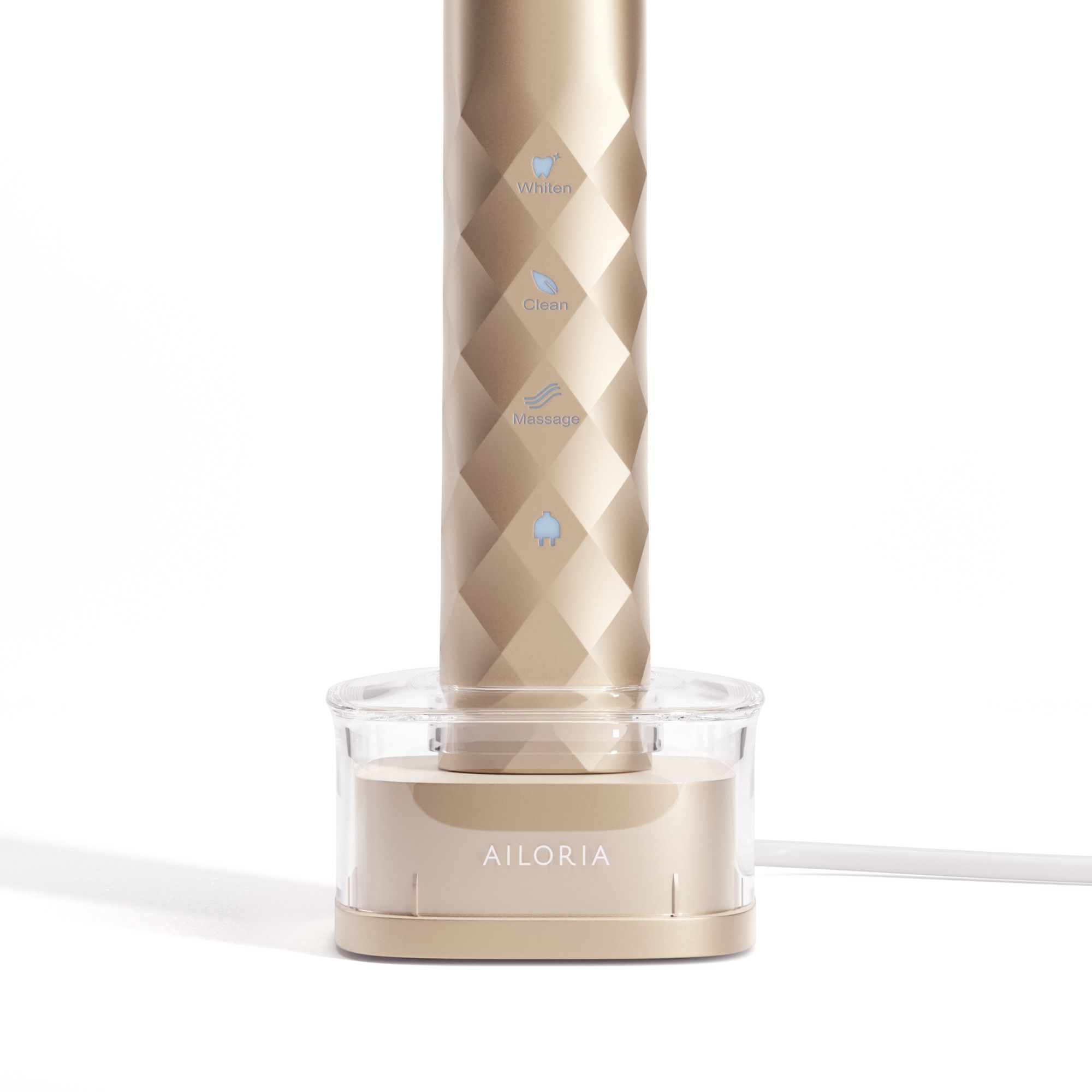 AILORIA induktive Ladestation. Goldfarbenes Gehäuse. Ein Gerät wird geladen. USB-Kabel.