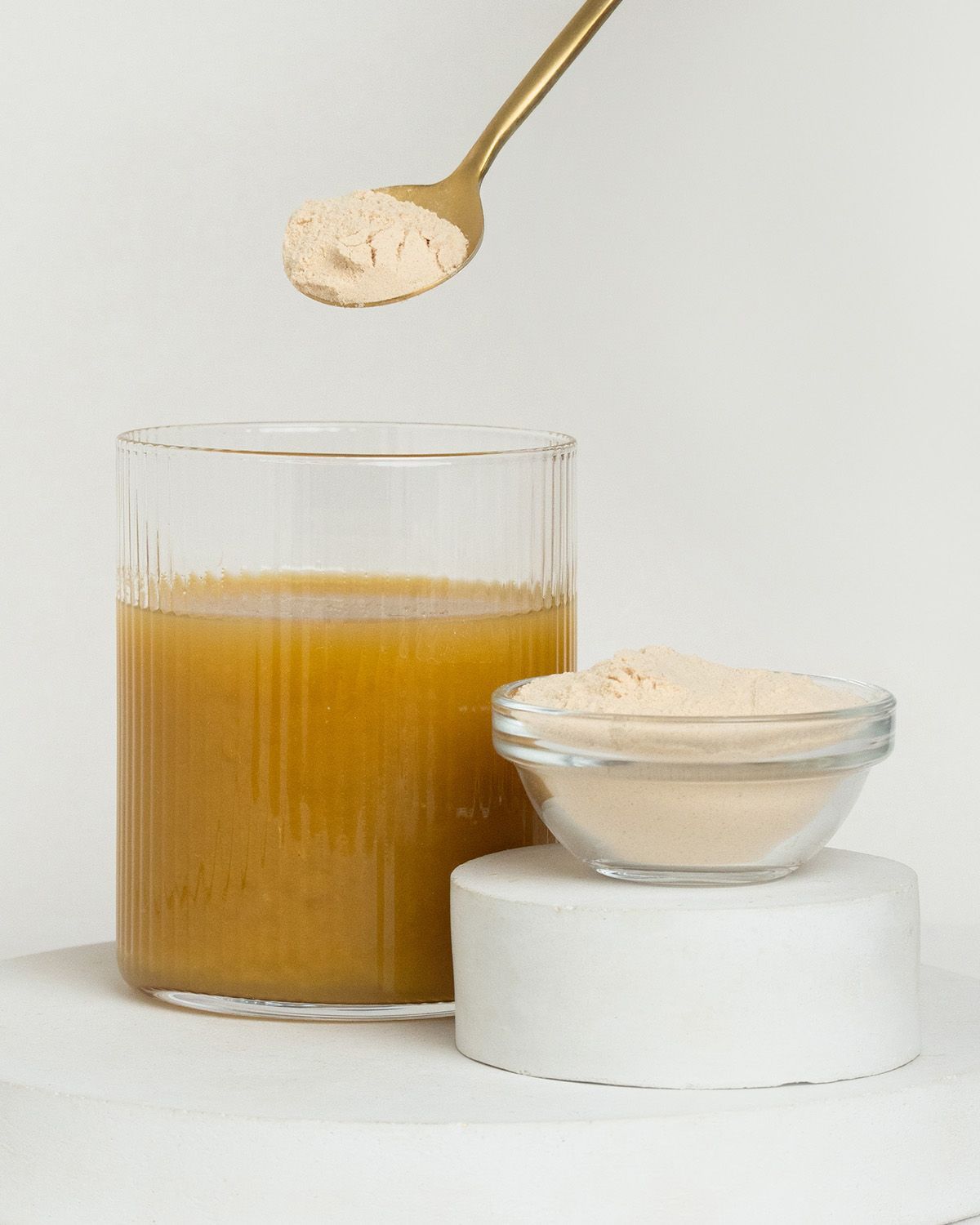 Glas Saft, Schale mit Baobab Pulver und Löffel mit Pulver.
