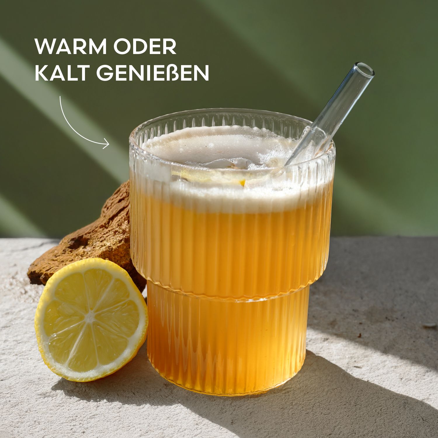 Glas mit gelbem Getränk und Strohhalm, daneben Zitronenscheibe und Chaga-Pilz.