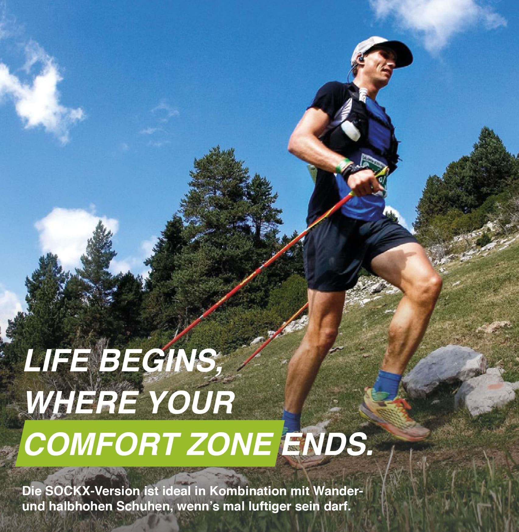 Mann beim Wandern mit Stöcken. Trägt blaue Kompressionssocken. Text: "LIFE BEGINS, WHERE YOUR COMFORT ZONE ENDS."