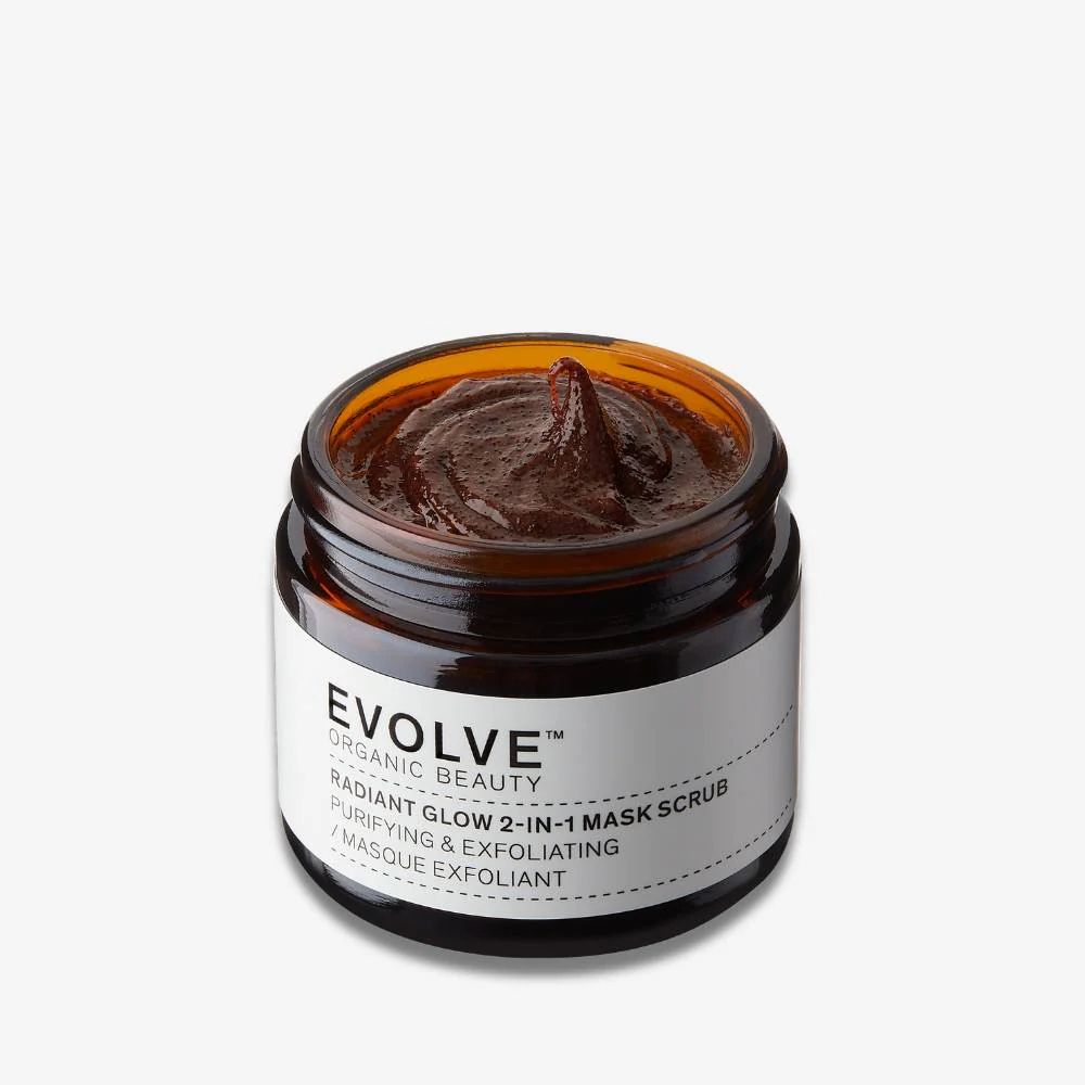 Braune Gesichtsmaske in einem braunen Glasbehälter. Auf dem Etikett steht "EVOLVE ORGANIC BEAUTY RADIANT GLOW 2-IN-1 MASK SCRUB".