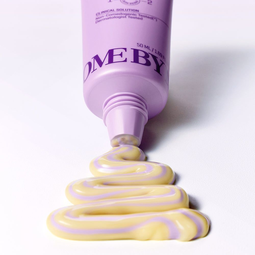 Lila Tube, Creme wird herausgedrückt. Creme in gelben und lila Streifen. Aufschrift: SOME BY MI.
