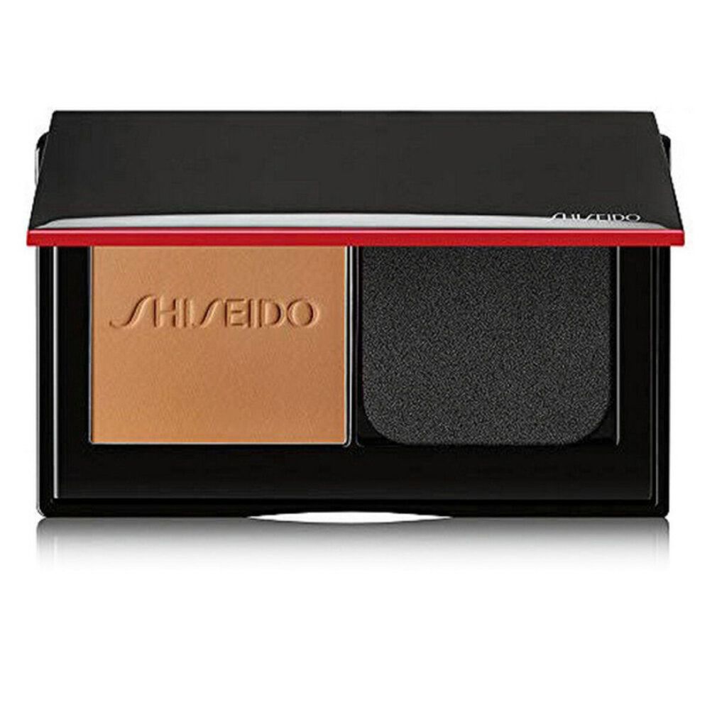 Kompakt-Make-up-Puder mit Schwamm. Schwarze Hülle mit rotem Akzent. Marke Shiseido sichtbar.