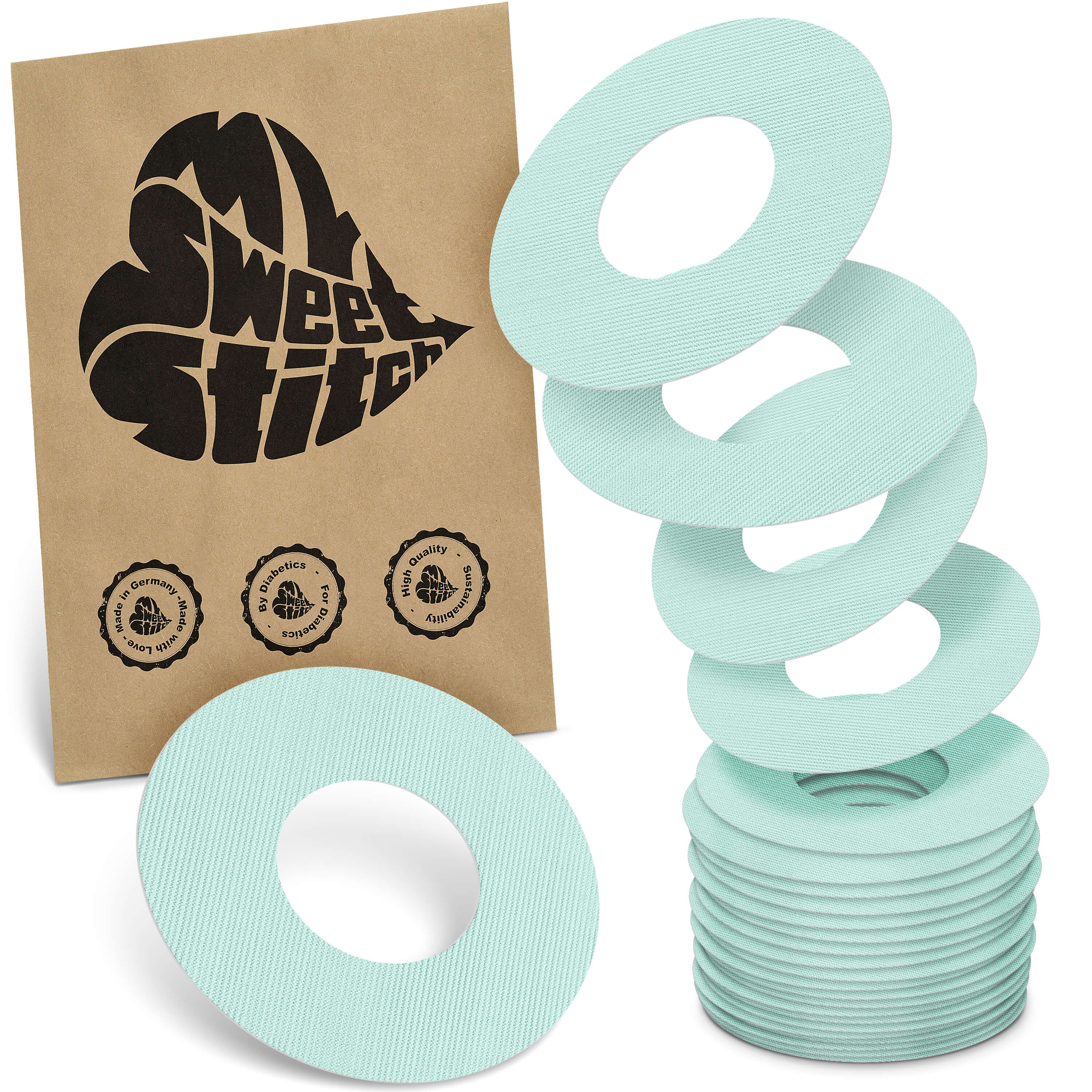 Hellgrüne, ringförmige Pflaster. Neben einer Papiertüte mit Logo und Siegeln. Stapel von Ringen und einzelne Ringe.