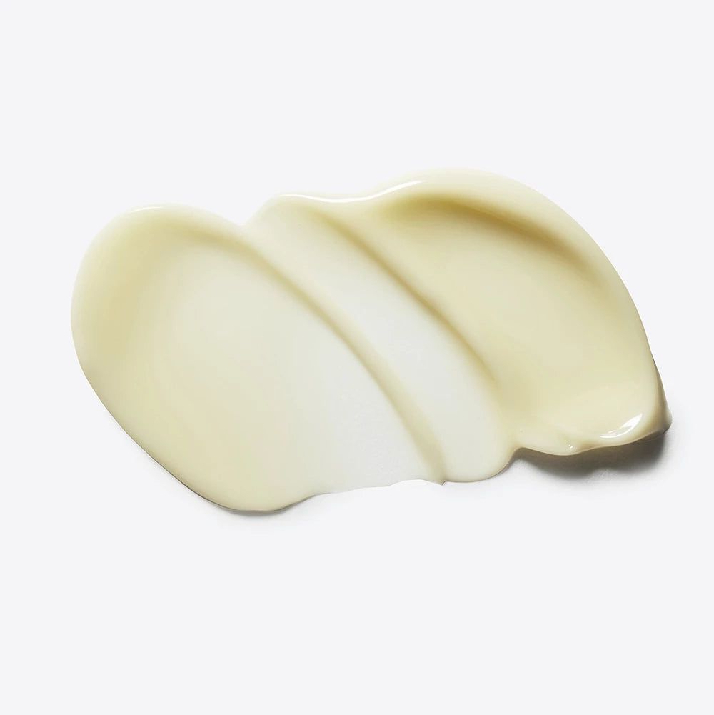 Creme-Abstrich auf weißem Hintergrund. Die Creme ist hellgelb und hat eine glatte Textur.