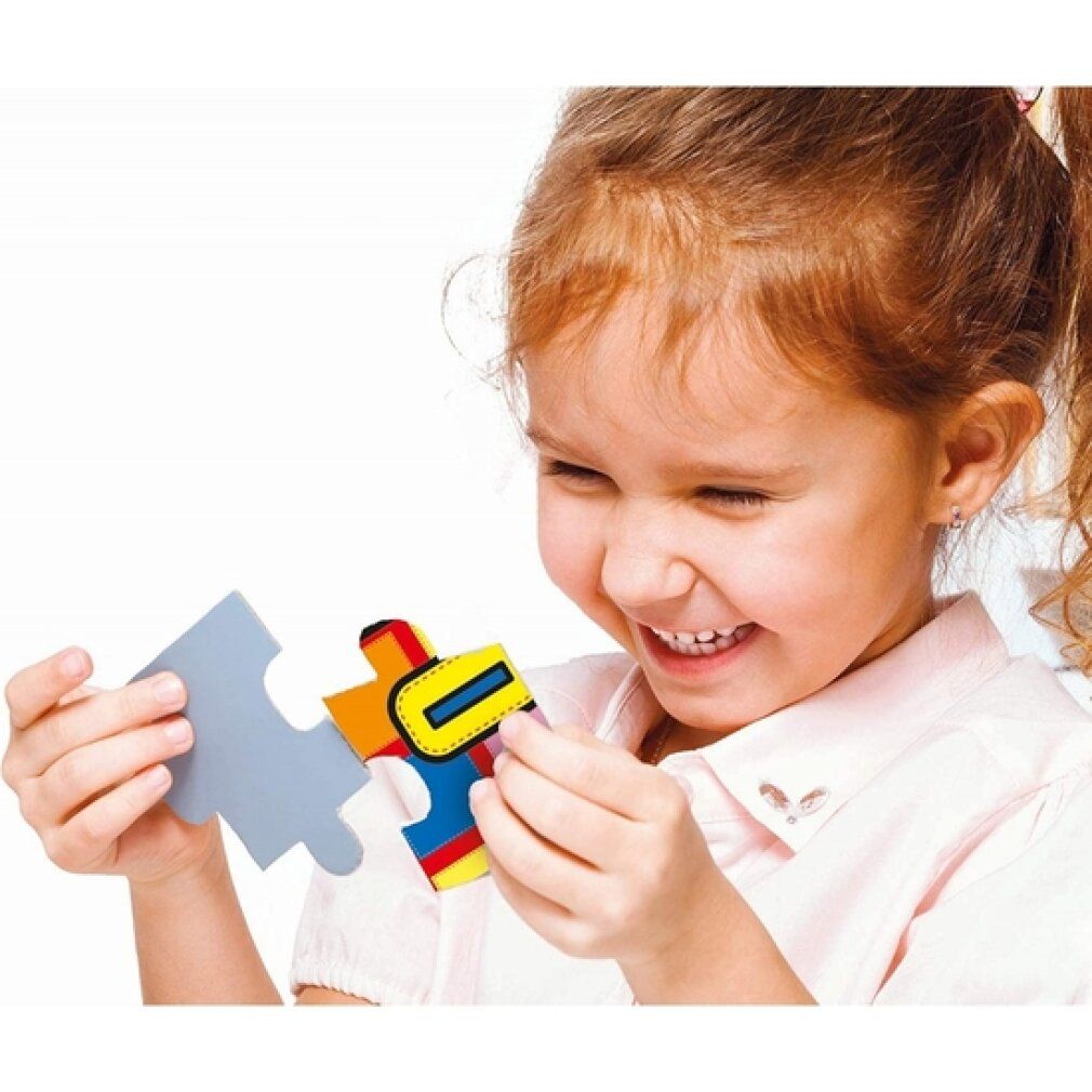 Kind hält Puzzleteil. Puzzleteil mit gelben, roten, blauen und grünen Elementen. Kind lächelt. Hintergrund weiß.