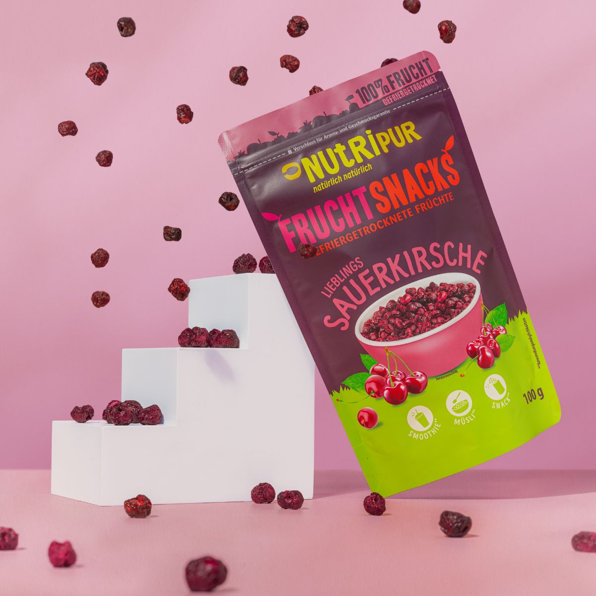 NutriPur Sauerkirschen-Packung, Kirschen auf Treppe. Rosa Hintergrund.