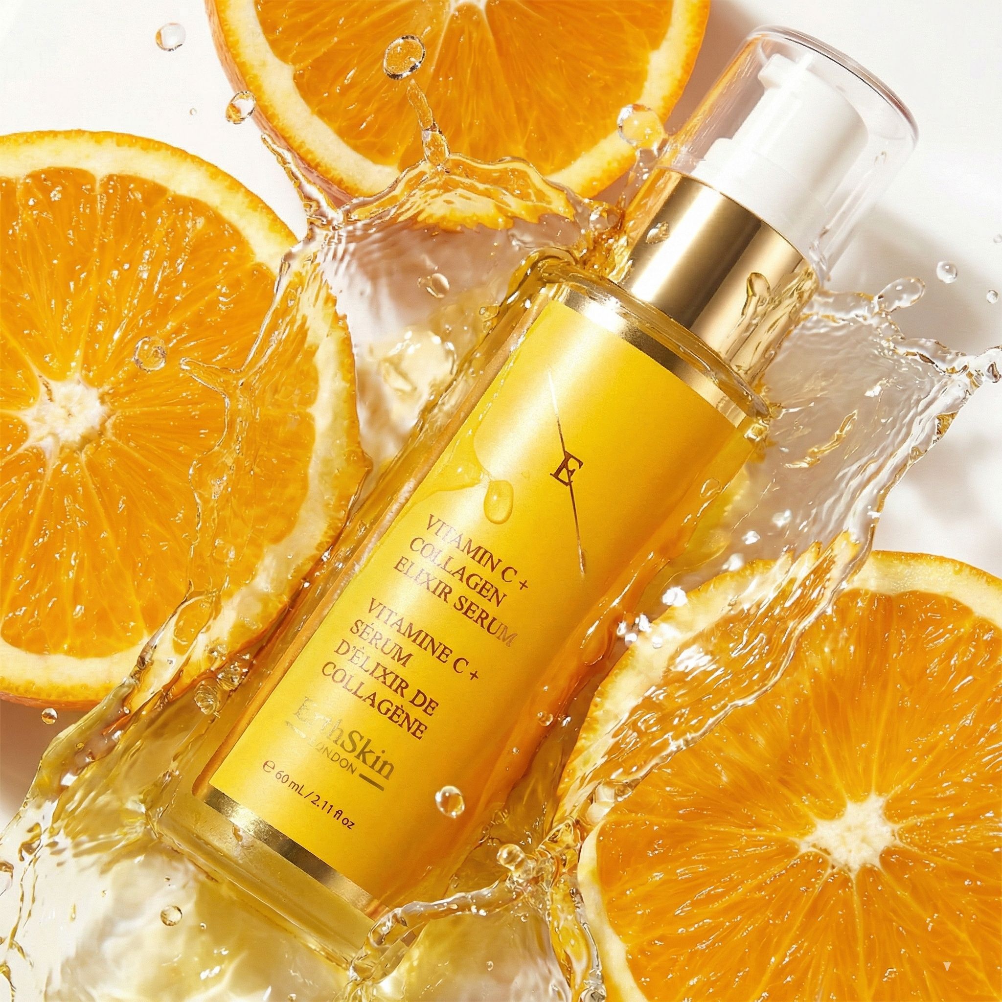 Flasche ErthSkin Vitamin C + Kollagen Elixir Serum umgeben von spritzendem Wasser und Orangenscheiben.