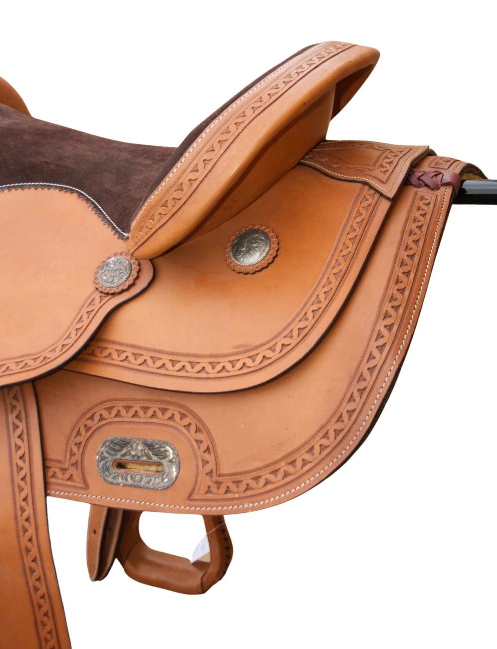 Nahaufnahme eines braunen Westernsattels. Geprägte Muster, silberne Beschläge, detaillierte Lederarbeit, braune Sitzfläche.