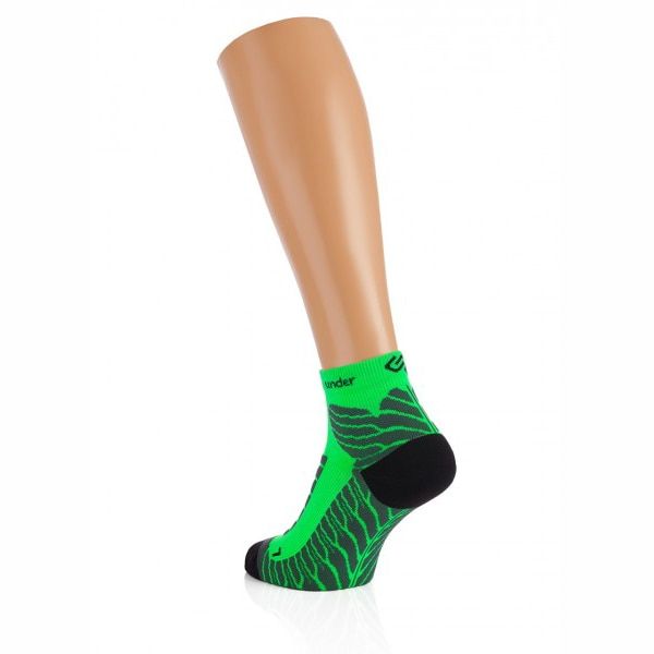 Grüne Sportsocken mit schwarzem Fersen- und Zehenbereich. Wellenförmiges Muster in Schwarz. Auf einem Bein-Mannequin präsentiert.