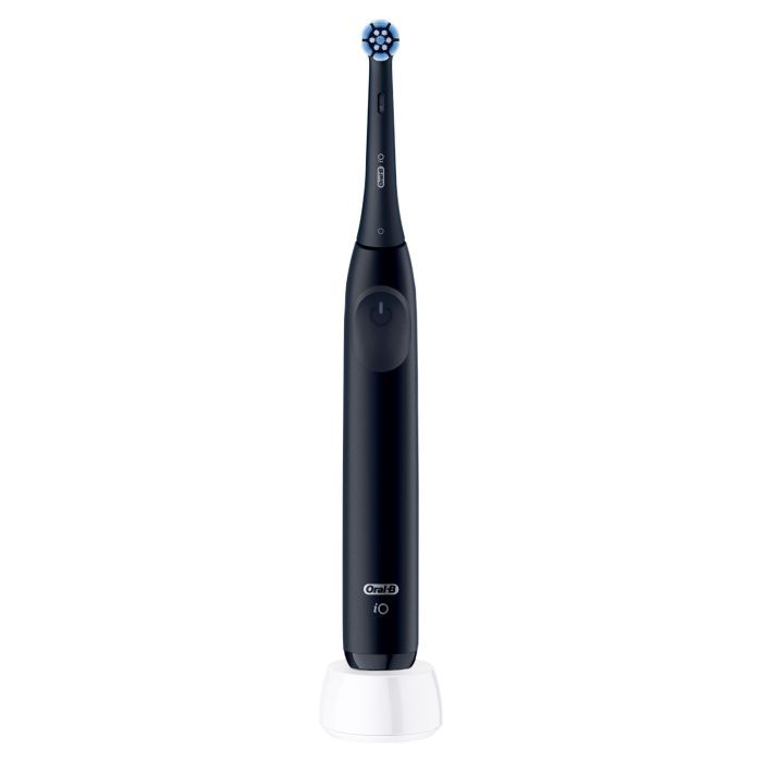 Elektrische Zahnbürste, dunkelblau, mit rundem Bürstenkopf. Auf weißer Ladestation. Marke Oral-B, Modell Io.