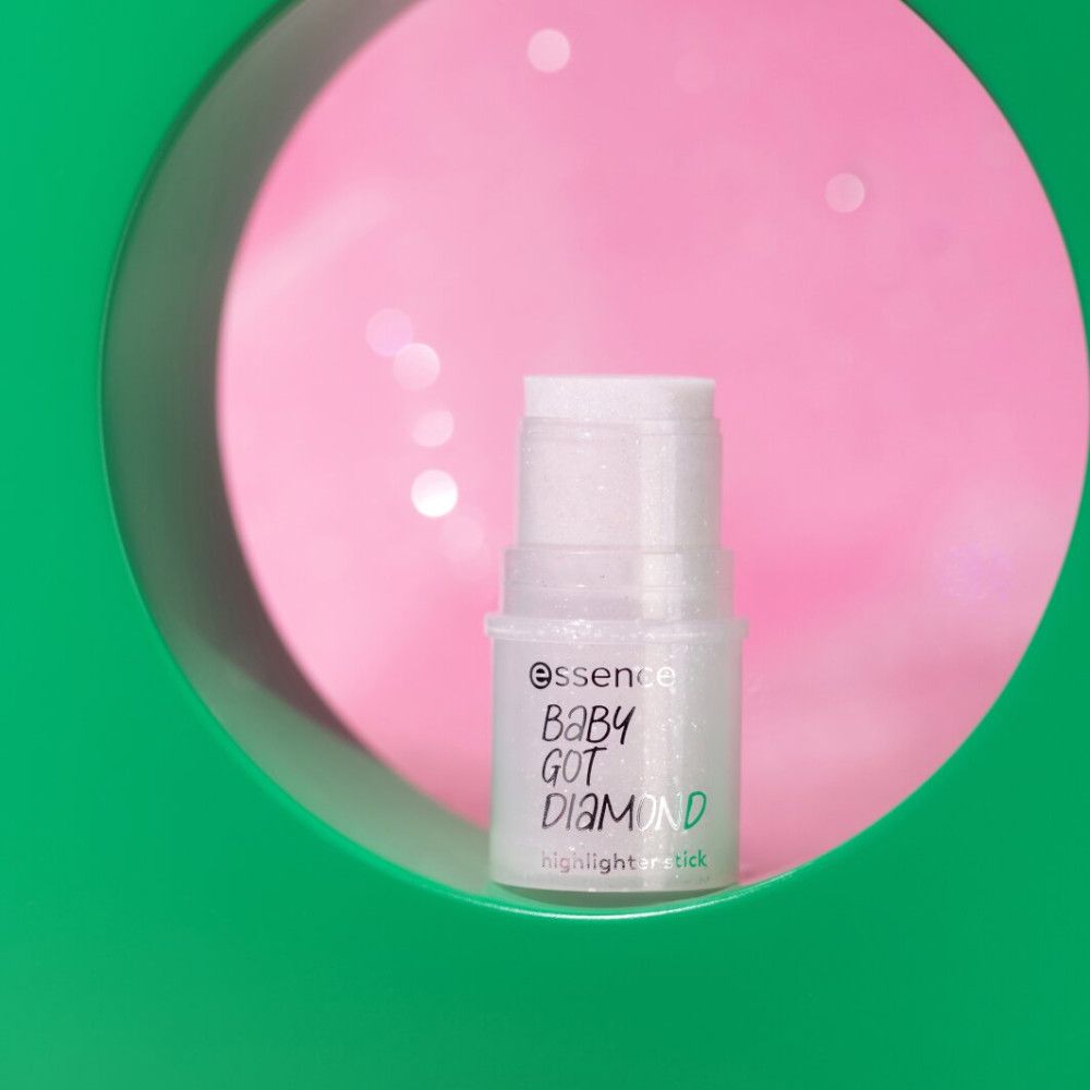Highlighter-Stick in grünem Rahmen vor rosa Hintergrund. Aufschrift: Essence, Baby Got Diamond, Highlighter Stick.