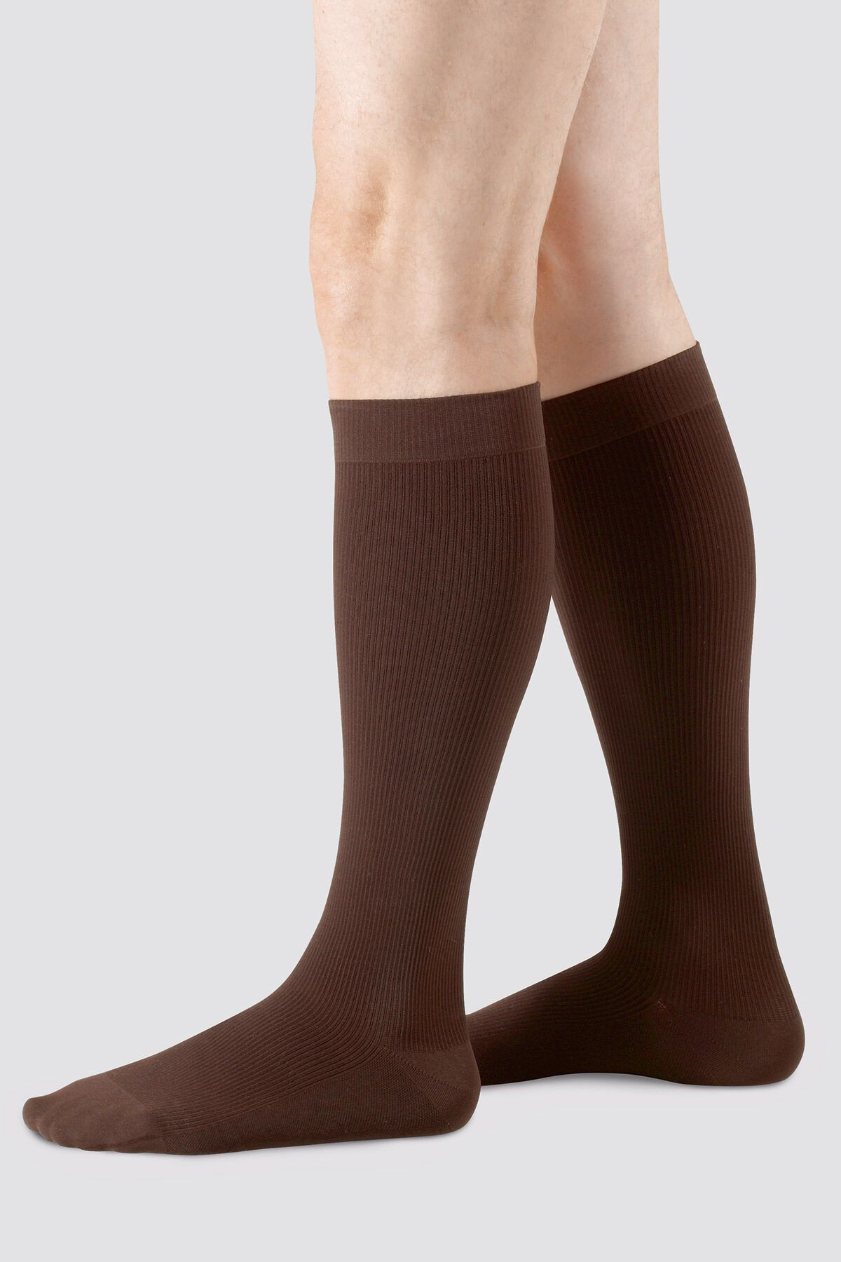 Braune Kompressionsstrümpfe, gerippt, mit Noppenhaftrand. Beinbekleidung, die bis zum Knie reicht.