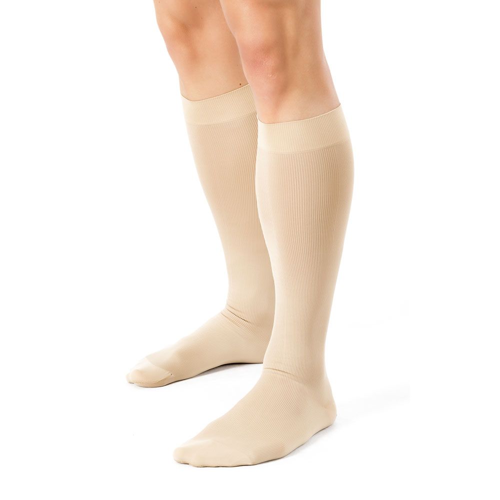 Beige Kompressionsstrümpfe bis zum Knie. Geripptes Material. Auf weißem Hintergrund. Beide Strümpfe sind sichtbar.