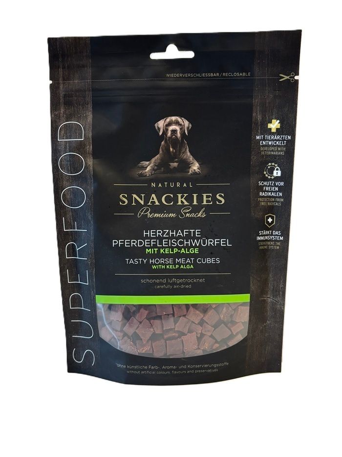 Verpackung mit Snackies Herzhafte Pferdefleischwürfel mit Kelp-Alge. Schwarze Tüte mit Produktbild und Text. Würfel sind sichtbar.